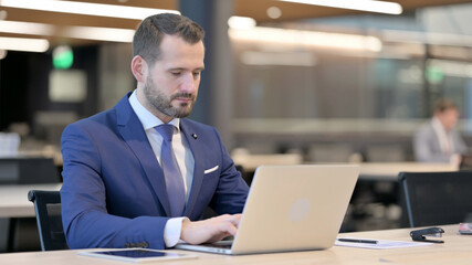 Middle Aged Businessman Working on Laptop in Office 