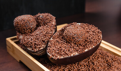 Chocolate Easter Egg filled with brigadeiro (brigadier), Goumert egg chocolate tradition in Brazil. Wood Background