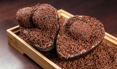 Chocolate Easter Egg filled with brigadeiro (brigadier), Goumert egg chocolate tradition in Brazil. Wood Background