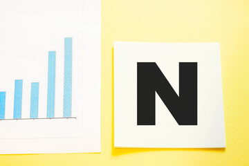Letter N on square office paper next to a growing business diagram