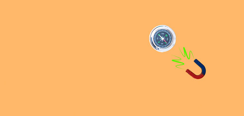 image of a compass and a magnet joined by the north on orange background and copy space concept cheat company