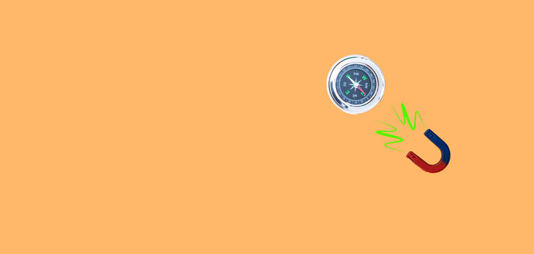 image of a compass and a magnet joined by the north on orange background and copy space concept cheat company