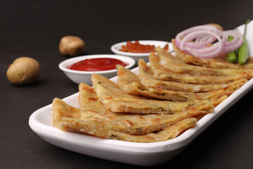 Traditional Indian food Aloo paratha or potato stuffed flat bread. served with pickle  tomato ketchup and curd, butter, onion chili.