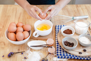 Man in the kitchen cooking a dough. Hands breaks an egg into a bowl ,hands pouring bitten egg ,Baking concept