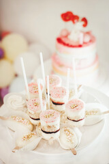 Beautiful sweet dessert on a stick on the background of a birthday cake
