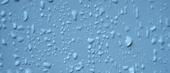 Raindrops on a white metal wall