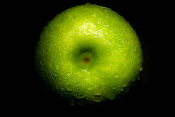 fresh green apple with water drops over black background
