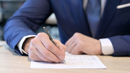 Close up of Hands of Businessman Writing on Paper 