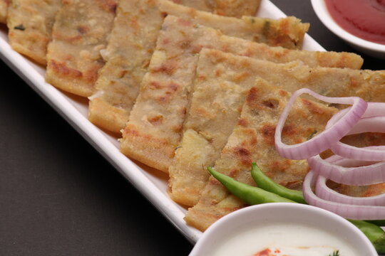 Traditional Indian food Aloo paratha or potato stuffed flat bread. served with pickle  tomato ketchup and curd, butter, onion chili.