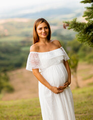 Fototapeta na wymiar Young pregnant woman at the forest