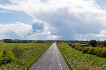 Fototapeta na wymiar Countryside lanscape. Empty asphalt road in empty fields and cloudy sky .