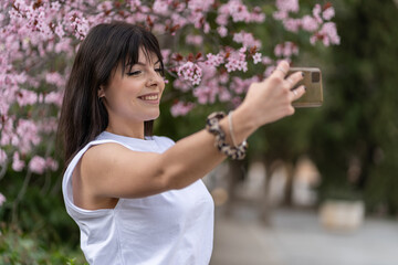 Obraz premium Pretty young woman makes a selfie with the smartphone
