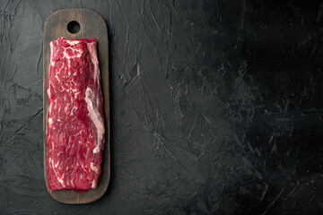 Beef fillet mignon cut raw, on black stone background, top view flat lay, with copy space for text