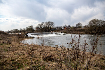 spring landscape with river and trees on the background of spring clouds 