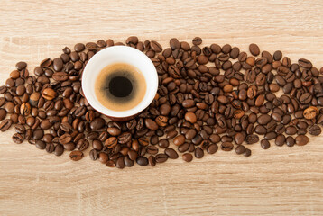Cup of coffee on wooden table with coffee beans