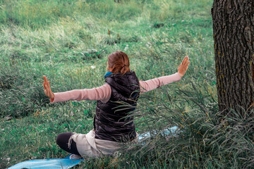 Young woman practicing yoga at the nature