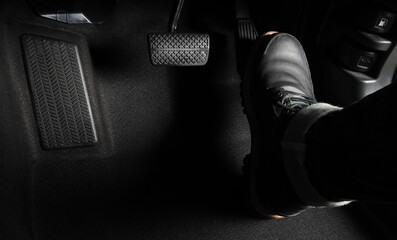 Close up the foot pressing foot pedal of a car to drive. Accelerator and brake pedal in a car....