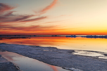 Obraz premium Beautiful winter sunset by the sea with iceberg