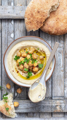 Classic hummus with parsley on a plate and pita bread.