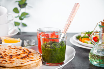 Homemade Indian naan flatbread with fresh salad and dips on the dinner table.