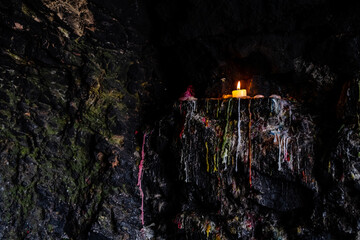 Candle on stone wall with colored candle wax