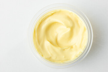 Top view on a cup of cheese sauce on white background
