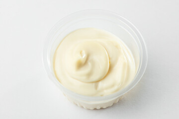 Close-up on a cup of mayonnaise on white background