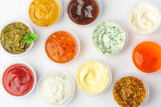 Top view on variety of sauces and condiments on white background