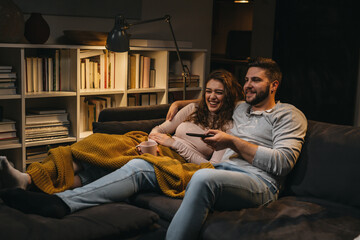 couple watching tv at home - Powered by Adobe