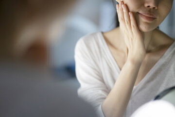 Woman checking face in mirror