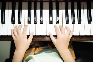 A boy is studying piano online with tablet.