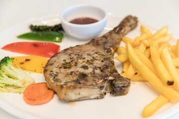 Grilled meat, Porkchops steak with pepper sauce and salad. Grilled pork chop with vegetable and burries sauce. Chef decorated pork chop steak.