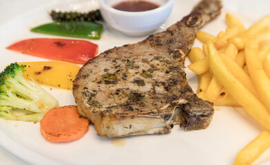 Grilled meat, Porkchops steak with pepper sauce and salad. Grilled pork chop with vegetable and burries sauce. Chef decorated pork chop steak.