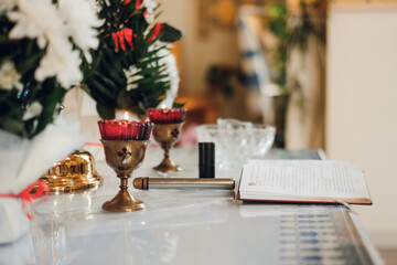 two candles and a bible on the table in the church