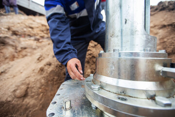 a man working in uniform is engaged in repairing the gas pipe, repairing the equipment with tools, iron communications repair gasman, improving their condition and improving the safety of people, unsc