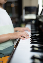 Obraz premium A boy is studying piano online with tablet.