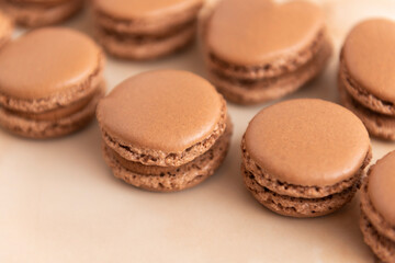 brown macarons with chocolate cream, on a wooden table