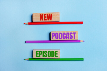 On a blue background, three colored pencils, three wooden blocks with text NEW PODCAST EPISODE