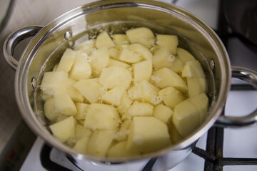 raw potatoes in a casserole on the stove