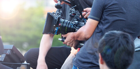 Blurry image of behind the scenes. Film Production crew team setting camera for shooting movie or...