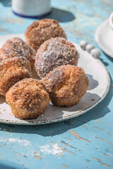 Blueberry muffin cut in half with butter and berries and muffins in background on a wooden platter