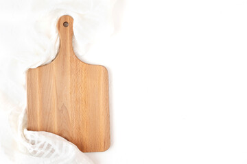 Wooden cutting board on white napkin and background