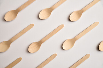 Pattern made from wooden spoons on white background. Flat lay wood spoons pattern group top view.