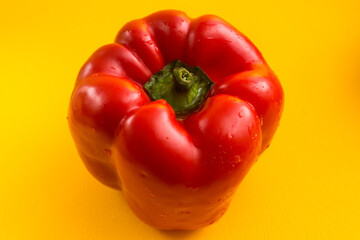 Sweet red pepper on a yellow background in the kitchen. Big vegetable for cooking