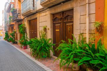 Fototapeta na wymiar Càlig, Baix Maestrat, Valencian Community, Spain. Beautiful flowery historic street. Traditional and typical spanish village. 