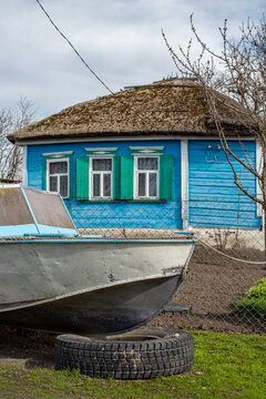 Puba on the ground near a village house with a reed roof