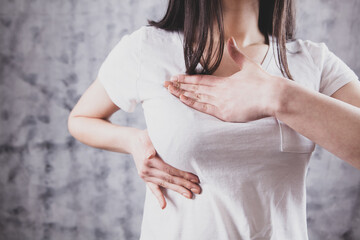 girl presses her hands on her chest chest pain