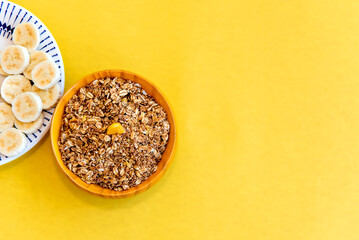Plate with sliced ​​bananas and granola. Top view.
