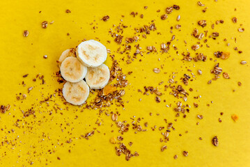 Plate with sliced ​​bananas and granola. Top view.