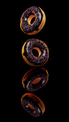 3D Render of two donuts on a reflective dark background.